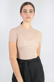 A woman standing wearing a blush-coloured Standard Issue Cotton Tulle Crop Tee.